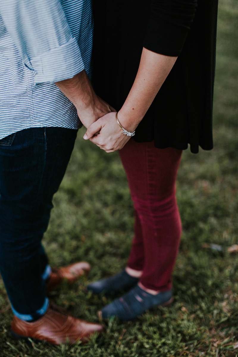 holding hands two person holding each other while standing on green grass ground couple